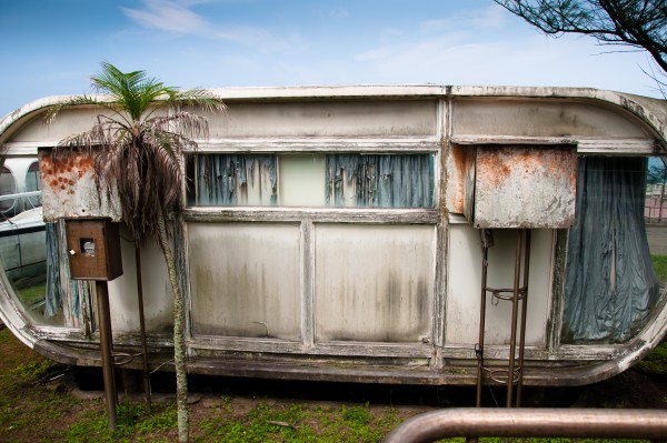 An old caravan-style pod covered in rust and grime.